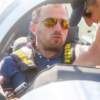 A pilot in a formula one racing aircraft wearing Bigatmo sunglasses and preparing for takeoff